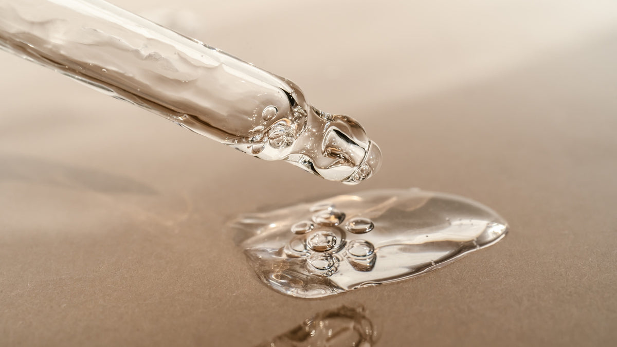Glass pipette above a pool of serum on a warm stone surface