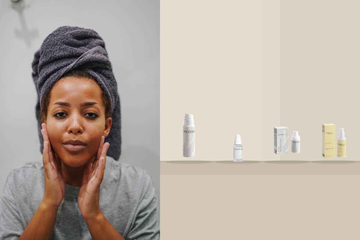 A woman with a towel wrapped around her hair, hands resting lightly at her jaw, beside VOLÉDESA LABS LUMINA, AQUAIRE, ÉVEIL and NOCTURNE in order on a stone counter