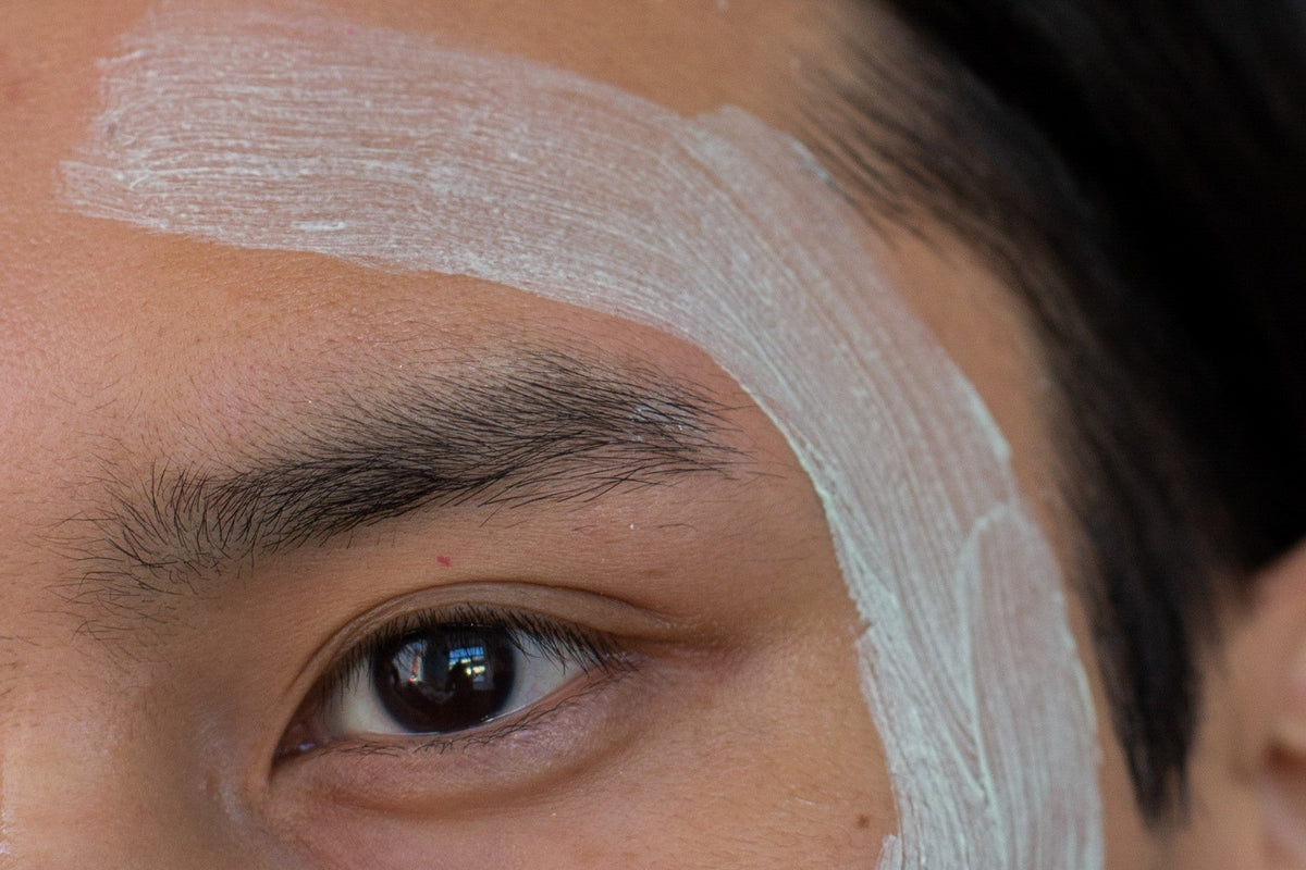 Swipe of clay mask across a man's cheek, close crop